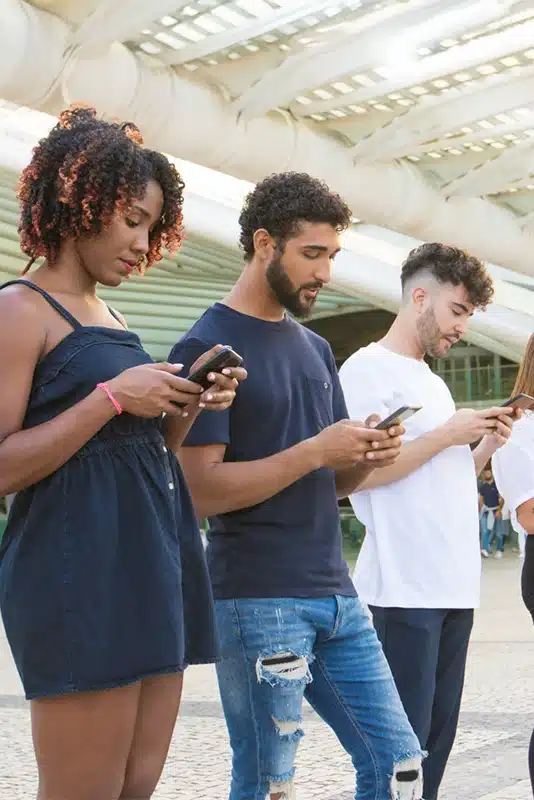 Group of young people using smartphones outdoors