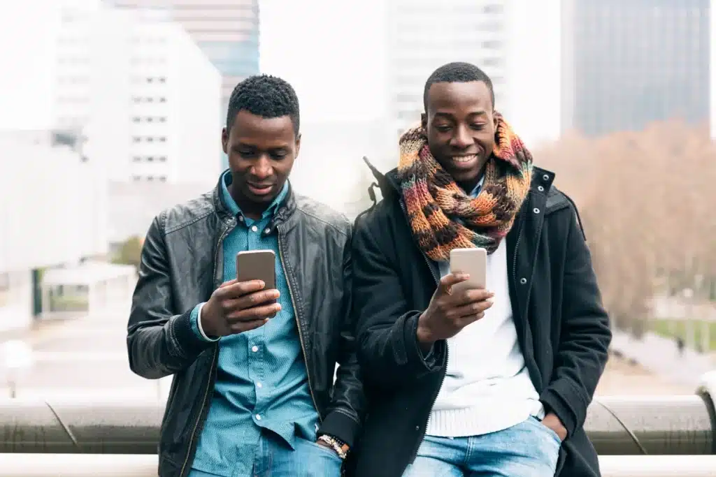 Two men using smartphones outdoors