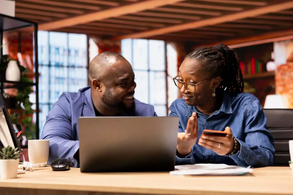 Happy couple using a laptop to apply for an installment loan online.
