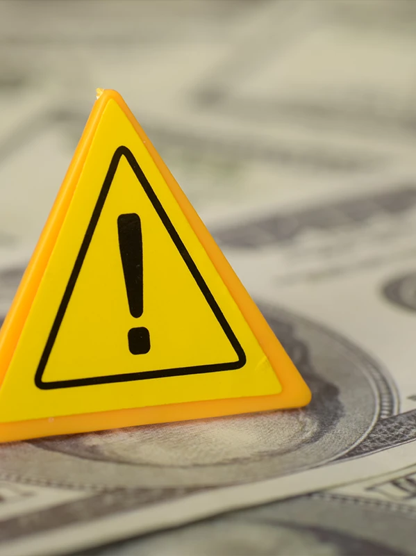 Exclamation mark symbol on a pile of money