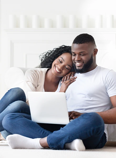 Happy couple applying for a loan online using a laptop