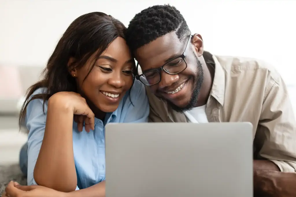 Smiling couple applying for an installment loan using a laptop