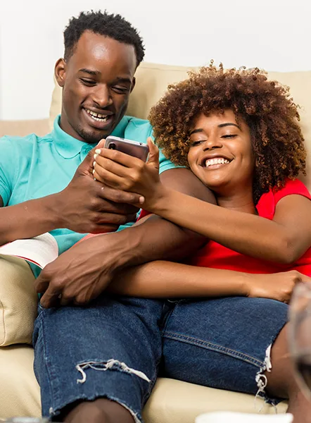 Happy couple checking their phone after getting approved for a payday loan