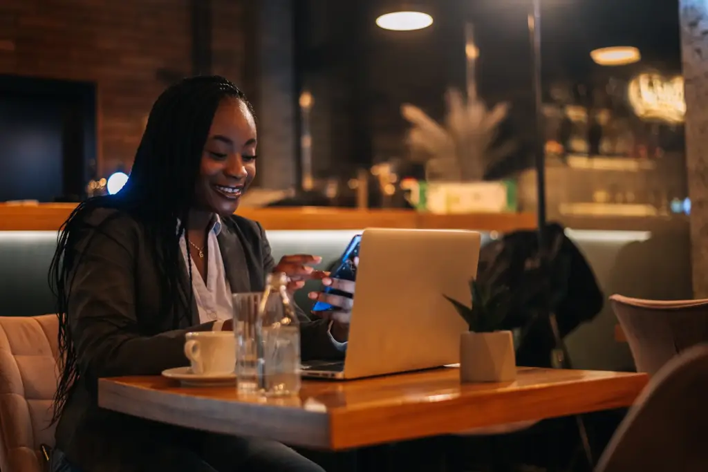 Happy woman using a laptop to apply for a payday loan online.