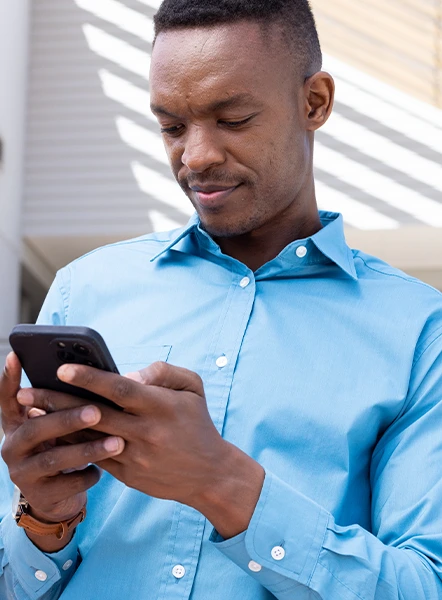Smiling man using his phone to apply for a payday loan online.