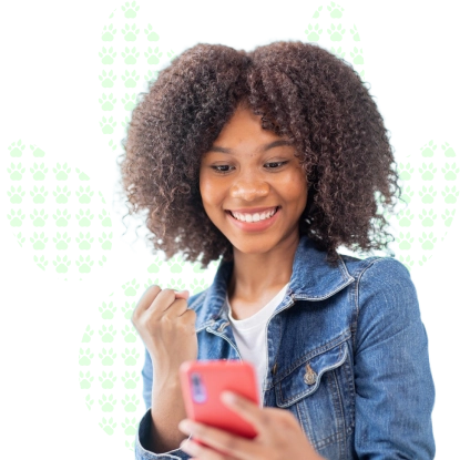 Smiling young woman holding her phone and getting happy, on a white background with a paw print pattern.