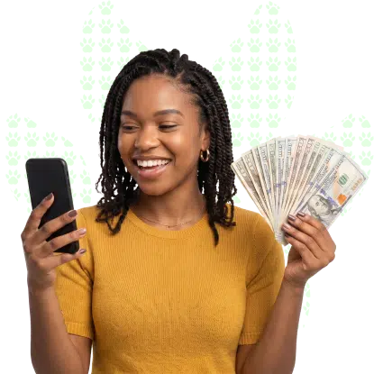 A smiling young woman holding cash in her hands while looking at her phone