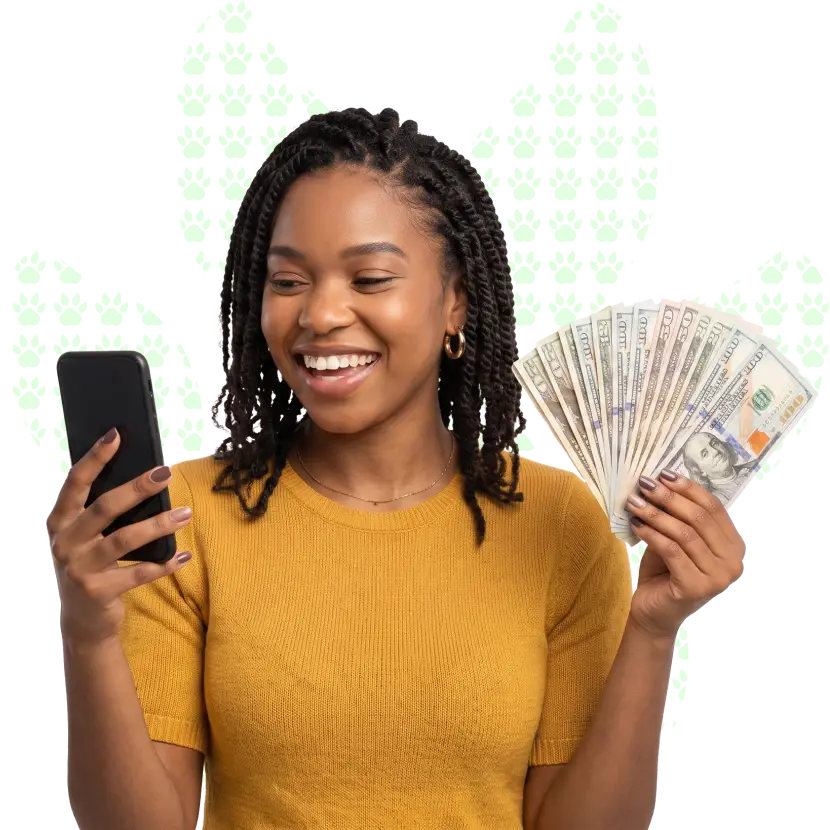 A smiling young woman holding cash in her hands while looking at her phone