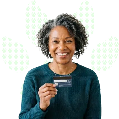 A happy woman smiling as she holds a credit card in her hands